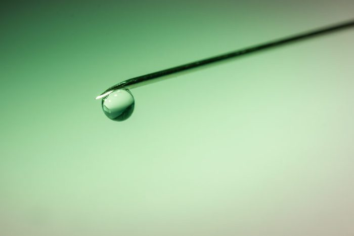 drop of fluid on the tip of a syringe needle 