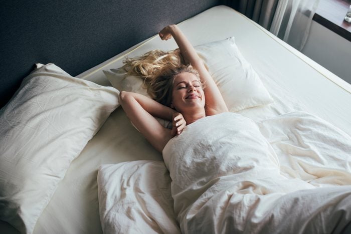 young woman waking up in the morning smiling