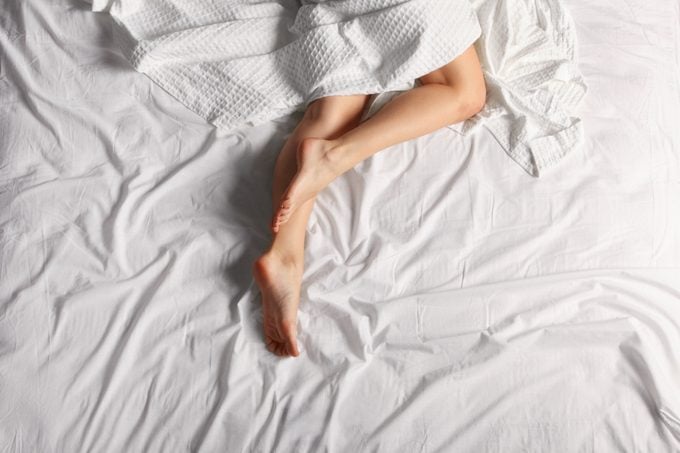 overhead shot of woman's legs on bed