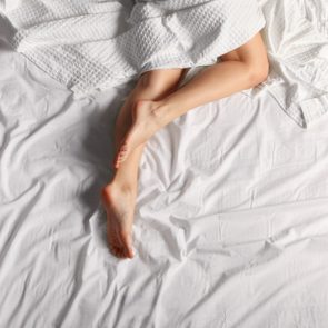 overhead shot of woman's legs on bed