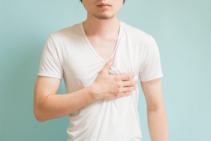 asian man holding breast chest