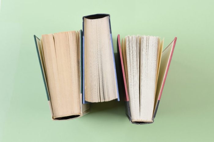Over head shot of three text books standing on end on a light green background.