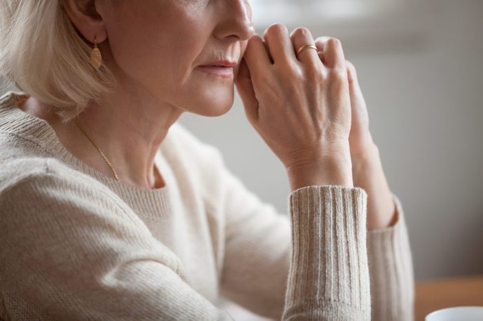 Close up view of thoughtful mature woman worried concerned about problems or disease, middle aged grey haired senior lady getting older thinking of loneliness depression grief anxiety concept