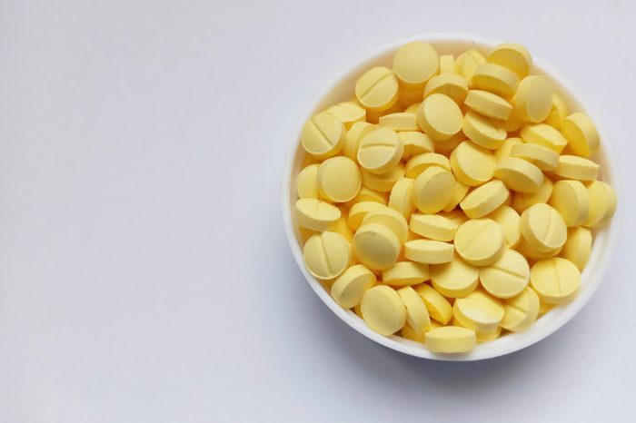 Yellow pills in white cap on white background. ; Shutterstock ID 1532737580; Job (TFH, TOH, RD, BNB, CWM, CM): RD