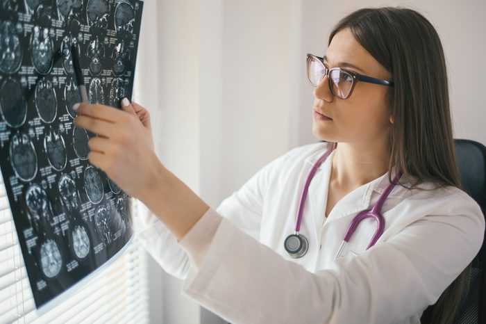 Young female doctor looking at x-ray image. Mri scan, magnetic resonance, radiology