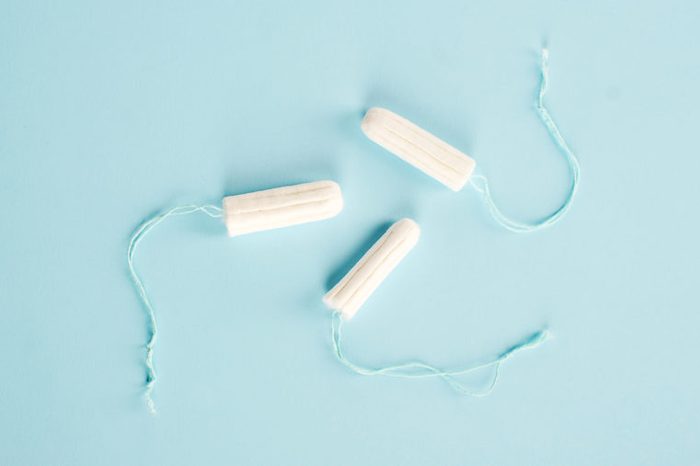 Hygienic tampons on a blue background. Three tampons of varying absorbency: normal, super, super plus. View from above.