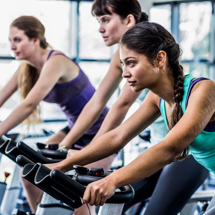 woman working out exercise bike class gym diverse asian