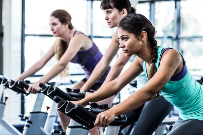 woman working out exercise bike class gym diverse asian