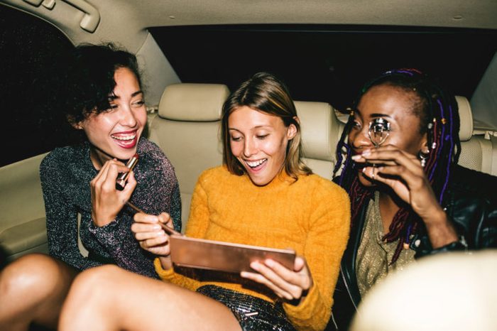 diverse women backseat of cab happy young