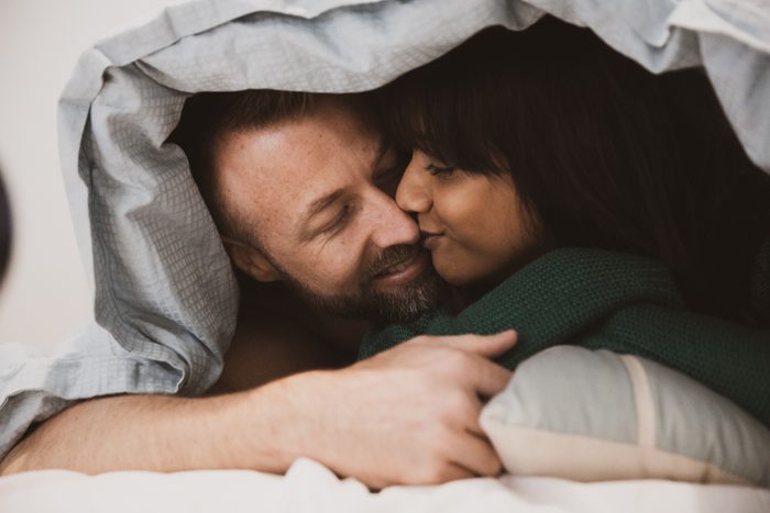 couple in bed under the covers