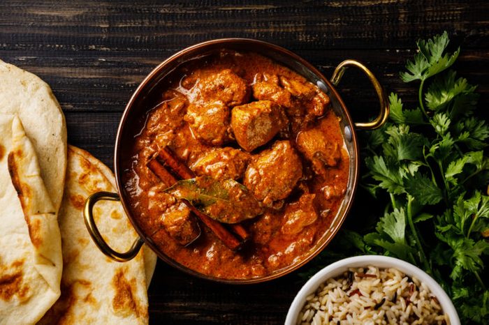 Chicken tikka masala spicy curry meat food Butter chicken with rice and naan bread on dark background close-up