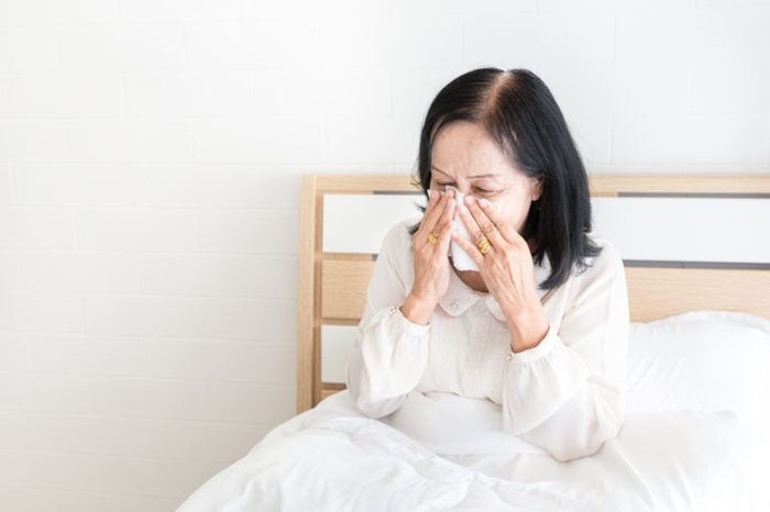 old asian female stay on white bed, influenza patient use tissue paper close her face, she cough and sneeze, elderly health care and health promotion, respiratory patient
