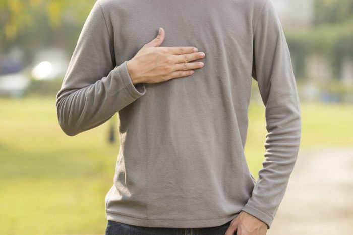 Man suffering from acid reflux at park