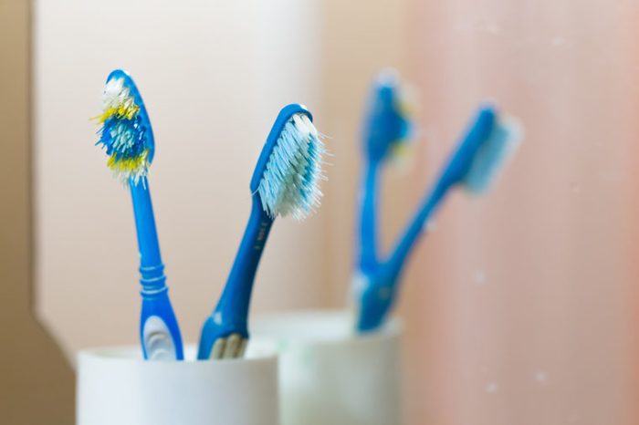 old used toothbrushes in cup