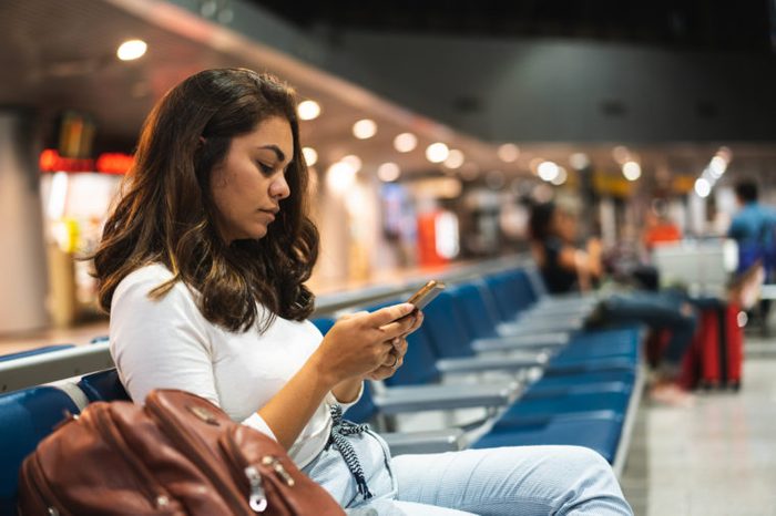 woman sitting in airport waiting to board flight