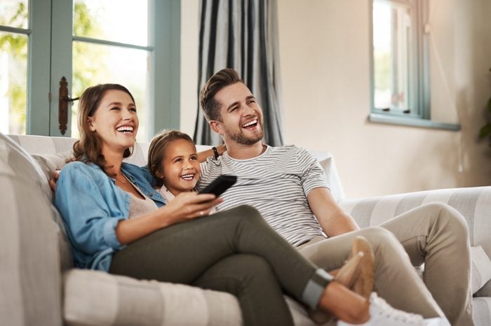family watching tv together laughing