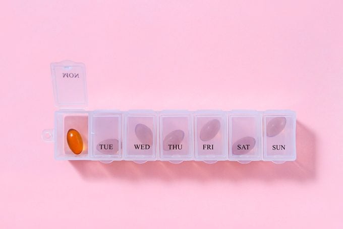 weekly pill box on pink background