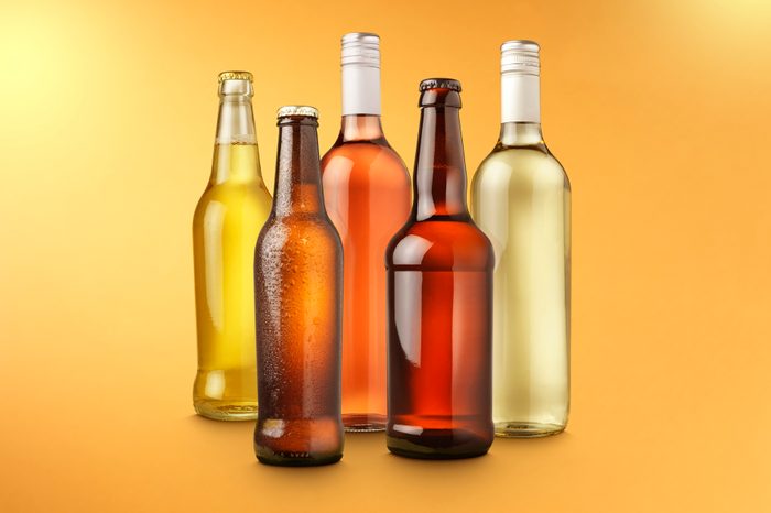 alcohol bottles on color background