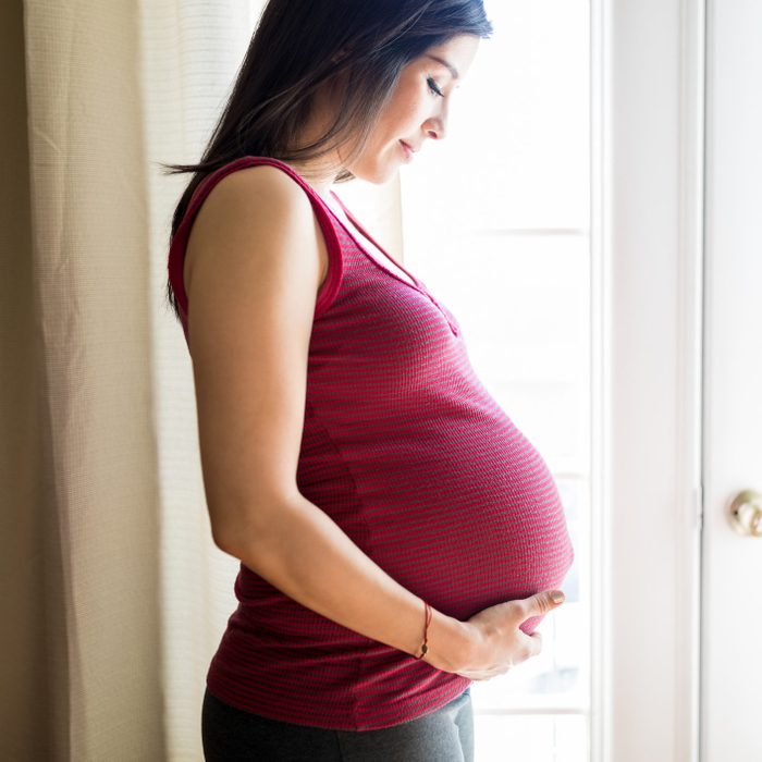 pregnant woman looking down at belly appreciating the miracle of life