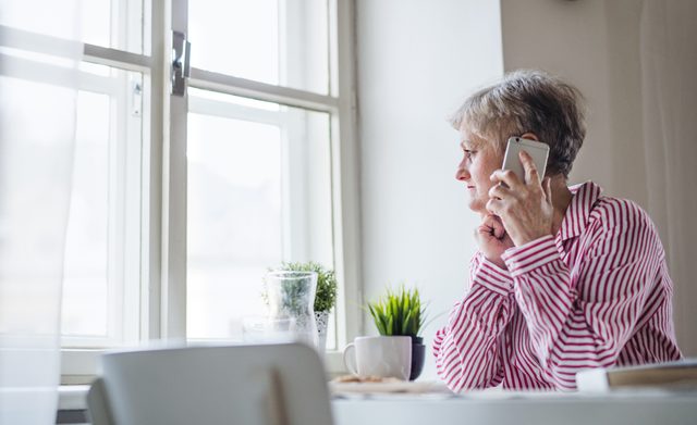 older woman sitting at home talking on the phone