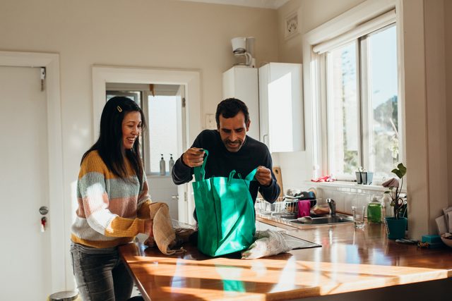 couple unpacking groceries in kitchen