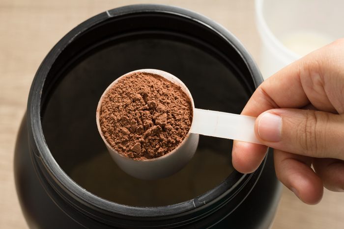 overhead shot of man holding a scoop of protein powder