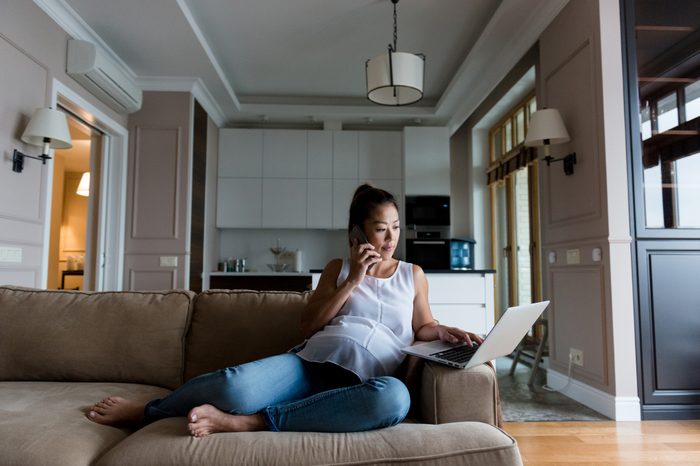 woman working from home on couch with laptop