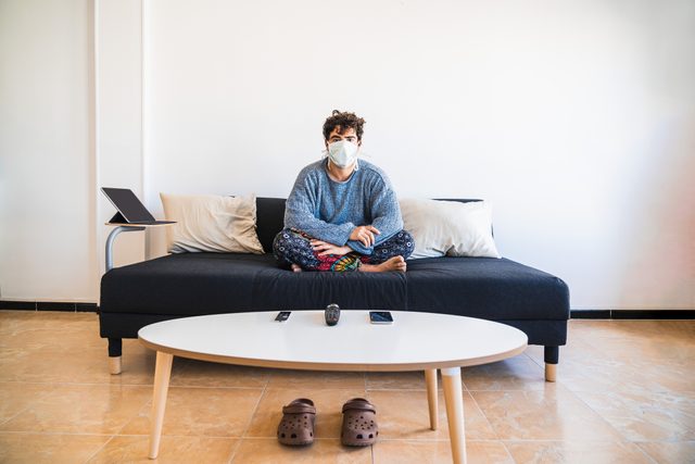 man sitting at home on couch during coronavirus pandemic quarantine