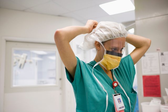 doctor putting on medical surgical face mask