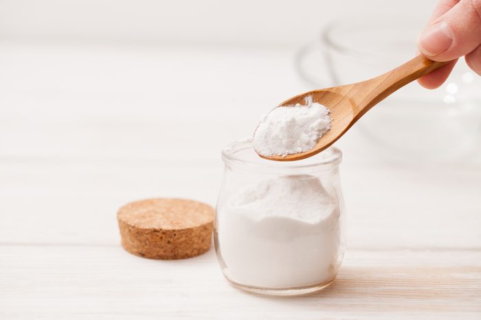 close up of baking soda in jar with wooden spoon