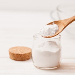 close up of baking soda in jar with wooden spoon