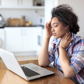 woman in pain while working at home