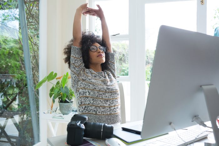 woman stretching at her desk