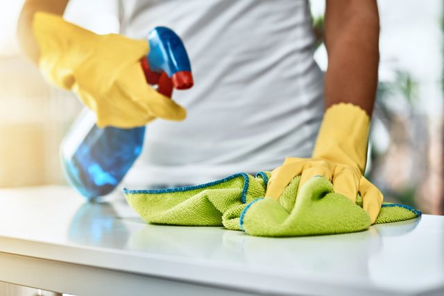 man cleaning and disinfecting home