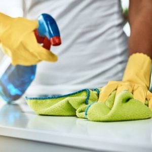 man cleaning and disinfecting home