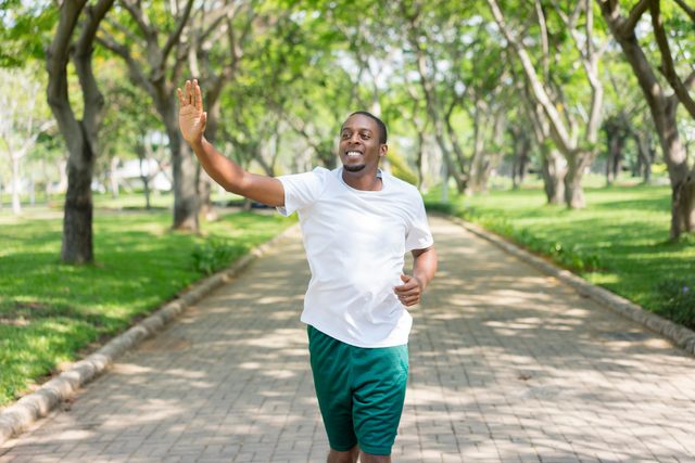 man running outside and waving hi to someone