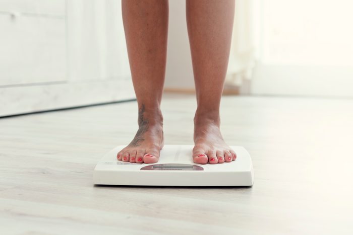 cropped shot of woman's feet on weight scale at home