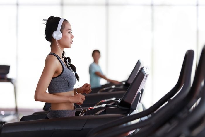 side view of woman walking on treadmill at the gym