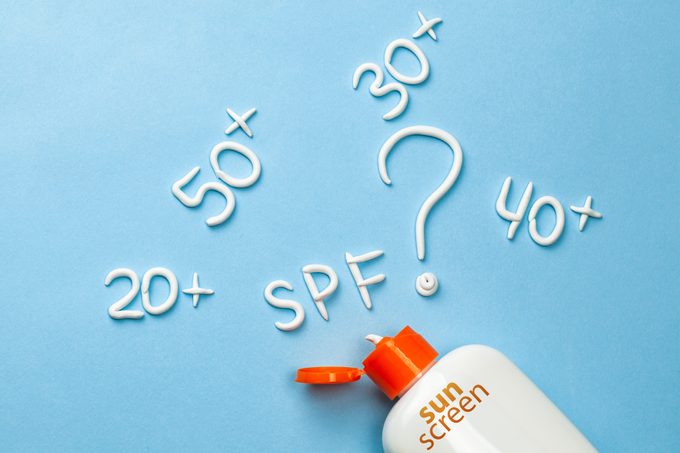 SPF sunscreen bottle concept on blue background