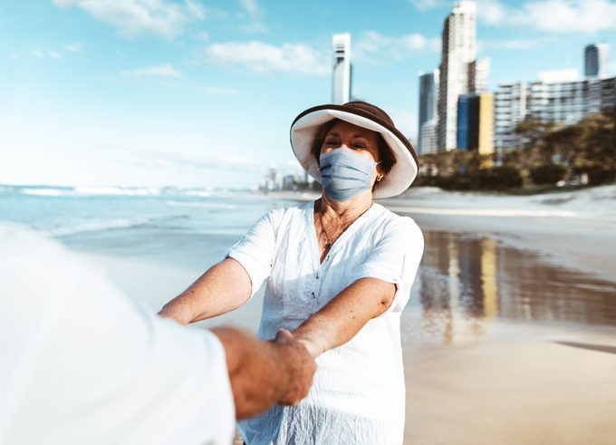 couple at the beach wearing face masks