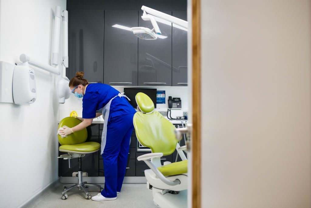 dental nurse disinfects dental examination room