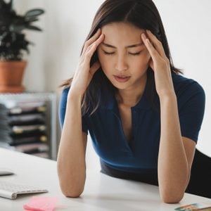 woman suffering from headache while working from home