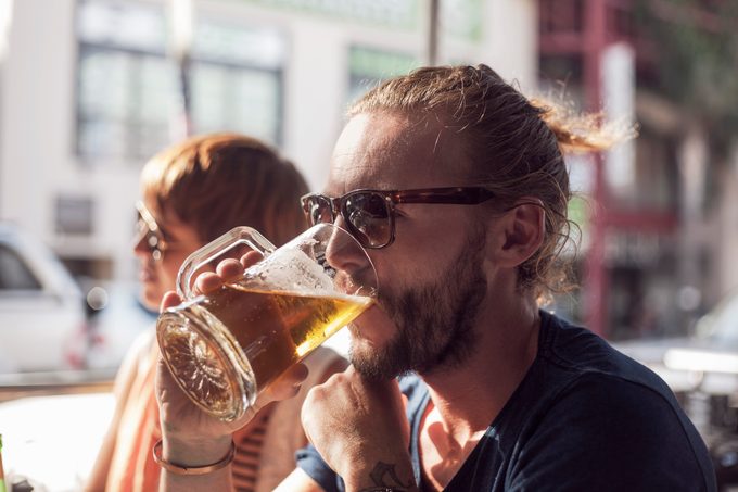 man drinking a beer at a restaurant