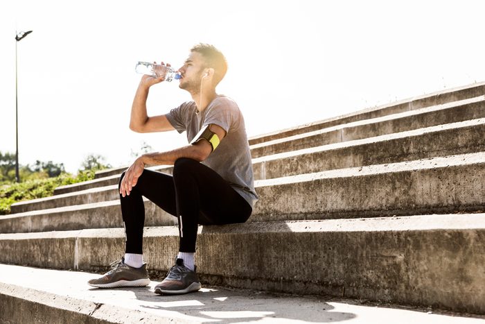 man taking a rest from exercise drinking water