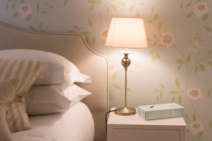 bedside table with lamp light on