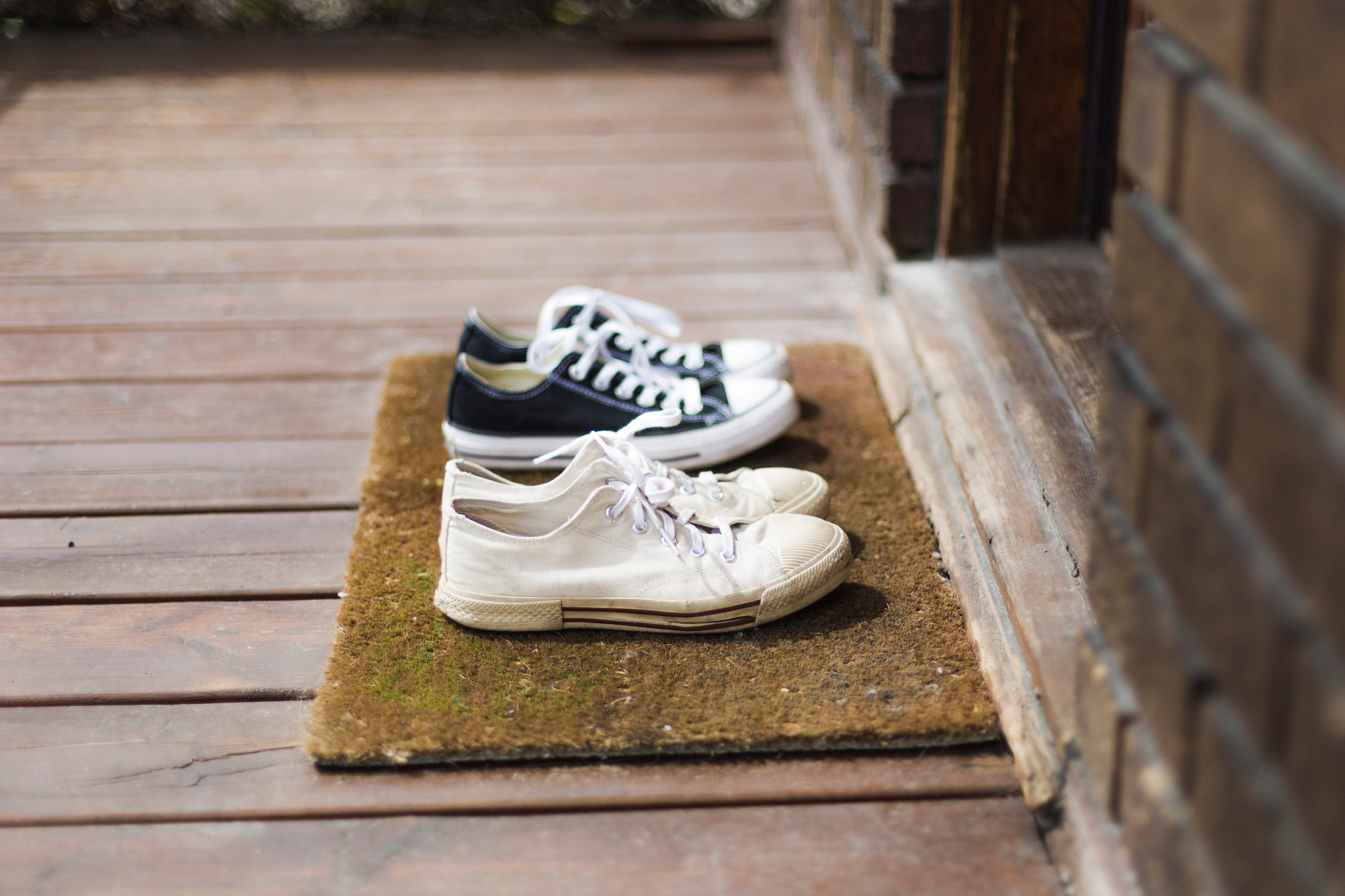 Home Moments - Two pair of black and white sneakers shoes on a porch