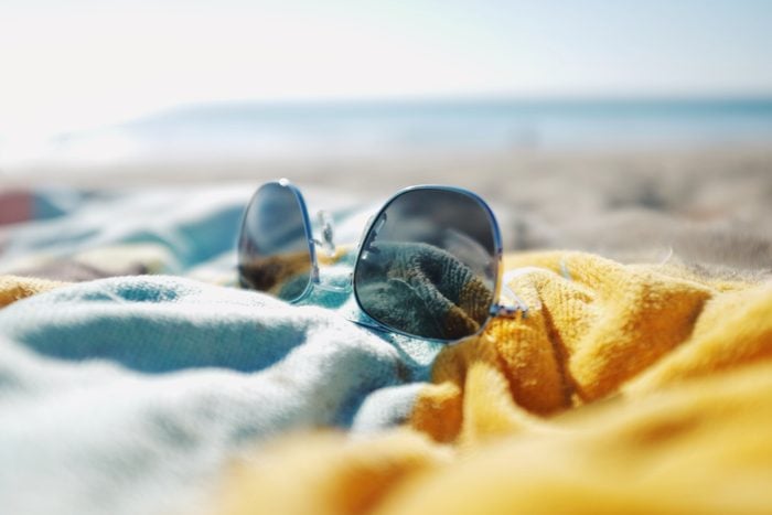 sunglasses laying on beach towel on the beach