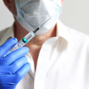 close up of doctor holding syringe