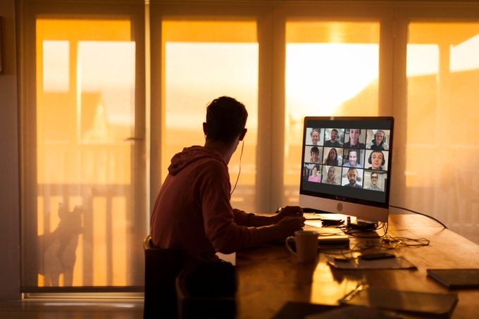 young man sitting at desk with zoom video call on computer
