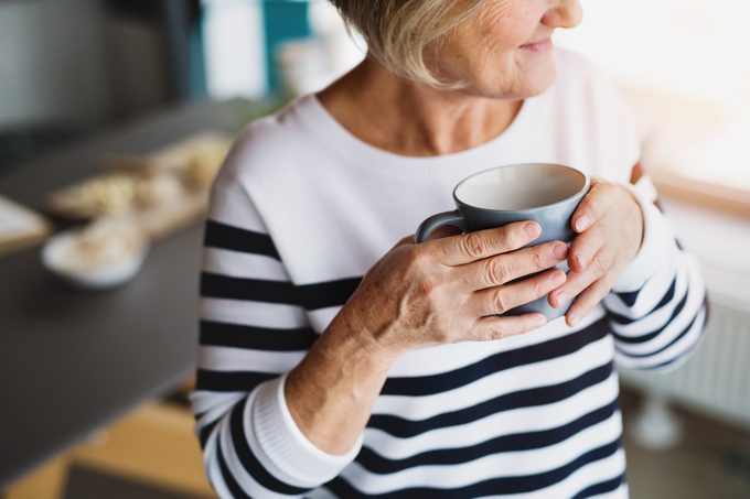unrecognizable senior woman holding cup of coffee